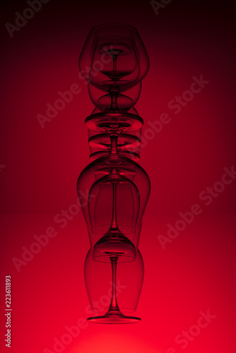 Inverted wine glasses on red background. Abstraction.