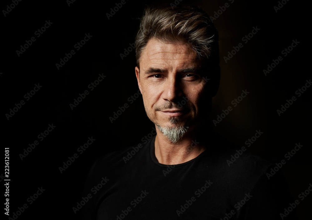 Fototapeta premium Portrait of an older white guy dark background