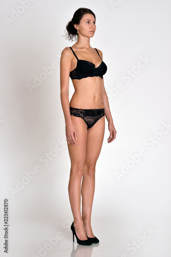woman  full length figure from  three-quarters angle in underwear.