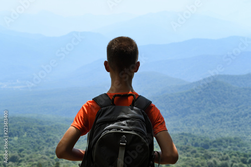 Young traveler with backpack on mountains background