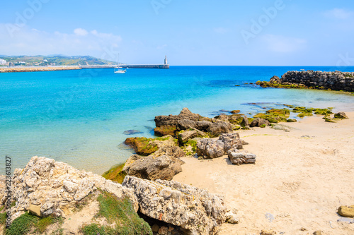 Rocks on sea coast and view of beach in Tarifa town, Costa de la Luz, Spain photo