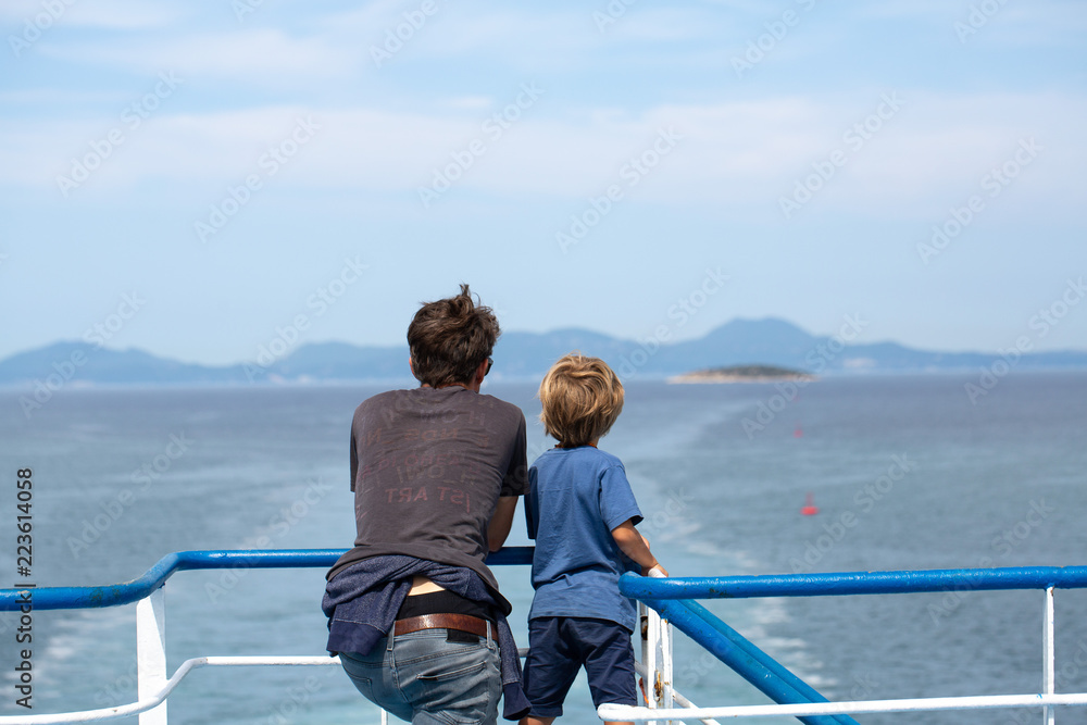 Father and son contemplating the sea