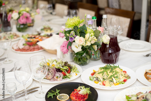 Served for a banquet table. Wine glasses with napkins, glasses and salads © Alex