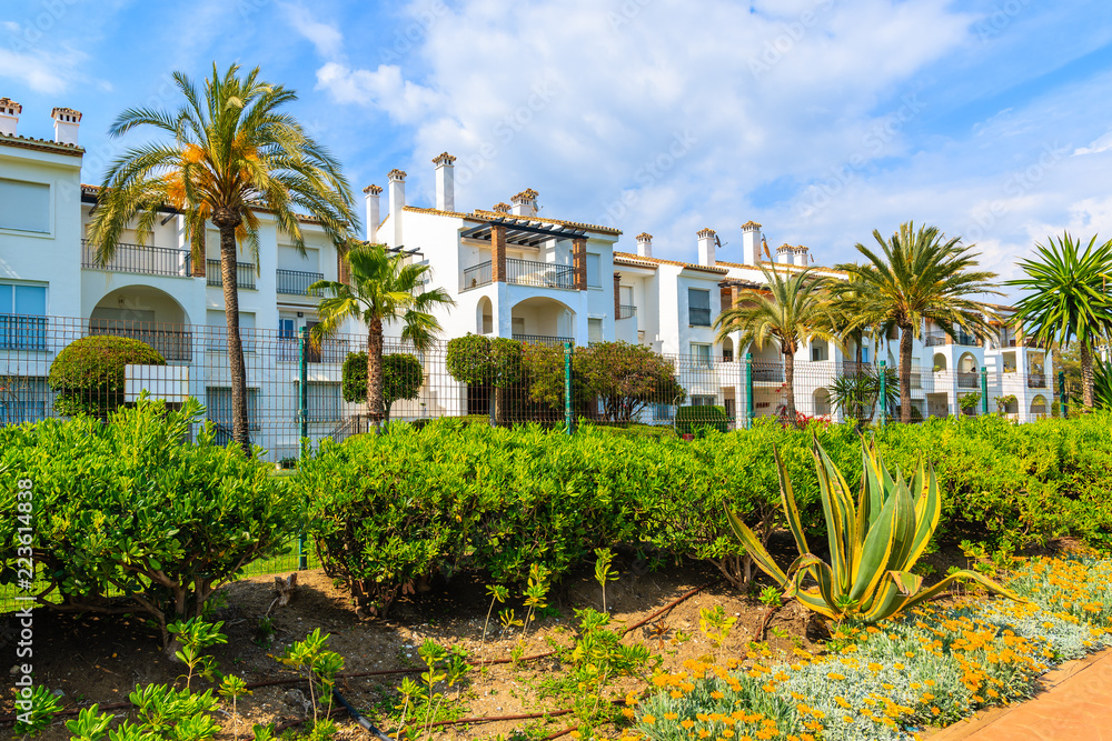 Holiday apartments in tropical garden on sea coast promenade near Estepona town on Costa del Sol, Spain