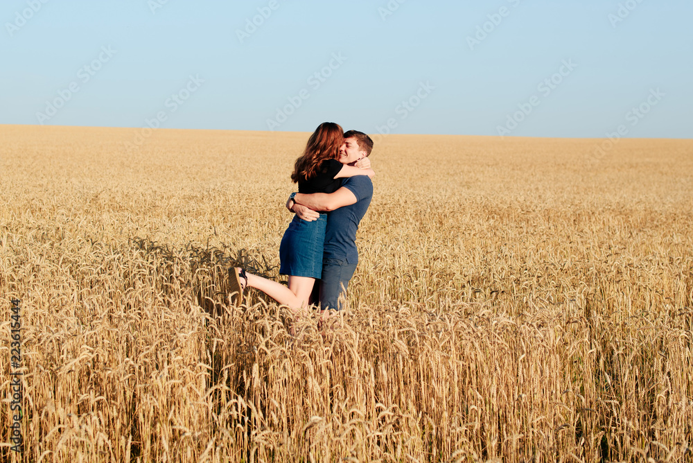 young loving couple in nature in summer on a background of field with oats young loving couple in nature in summer on a background of field with oats