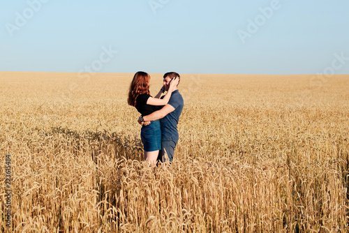 young loving couple in nature in summer on a background of field with oats © ShevarevAlex