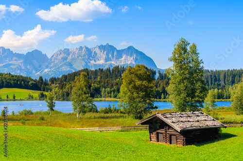 Obraz na płótnie Wooden hut on green meadow against Alps mountains near Schwarzsee lake on sunny beautiful summer day near Kitzbuhel, Tyrol, Austria w salonie