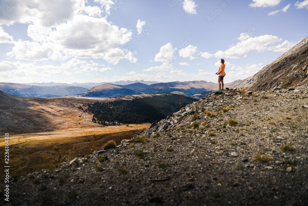 A woman standing on a mountain overlooking a gulch in Colorado. 