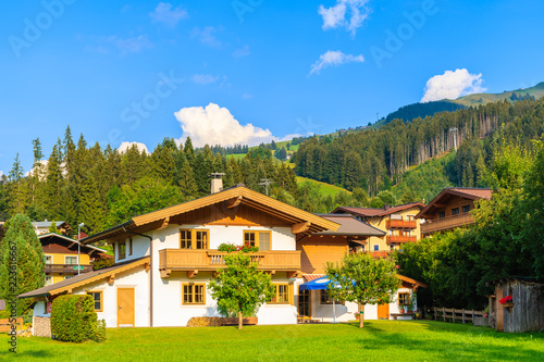 Traditional house on green meadow in Kirchberg mountain village,on sunny beautiful summer day, Kitzbuhel Alps, Austria