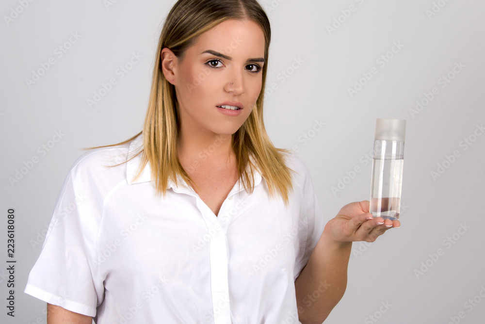 beautiful blond girl size plus model holding skin tonic micellar water in white skin dermatology concept beautiful blond girl size plus model holding skin tonic micellar water in white skin dermatology concept