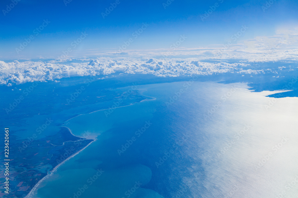 Blue planet Earth seen from high above through an airplane window. Unique panoramic high altitude aerial view of thunderstorm clouds over Venice Lagoon, Trieste Gulf seen through an airplane window. Blue planet Earth seen from high above through an airplane window. Unique panoramic high altitude aerial view of thunderstorm clouds over Venice Lagoon, Trieste Gulf seen through an airplane window.
