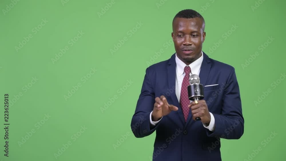 Young African businessman presenting something with microphone Young African businessman presenting something with microphone