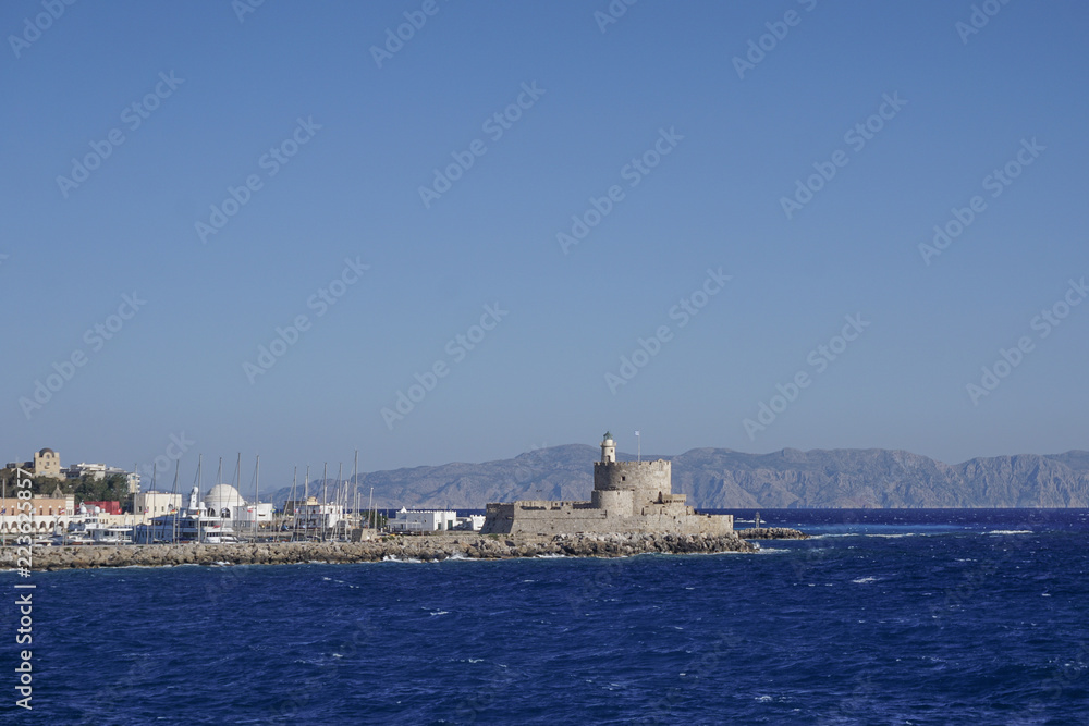 Rhodes, Greece: St. Nicholas Lighthouse (1863) on St. Elmo tower in St. Nicholas Fortress in Mandraki Harbor on the Aegean island of Rhodes. Rhodes, Greece: St. Nicholas Lighthouse (1863) on St. Elmo tower in St. Nicholas Fortress in Mandraki Harbor on the Aegean island of Rhodes.