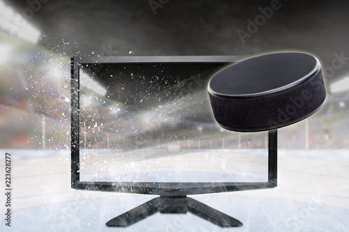 Hockey Puck Flying Out of TV Screen in Stadium. Concept of 3D or 4D sports, Virtual Reality VR or Computer Gaming