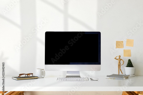 Workspace with mockup computer, coffee mug, flower, notebook and copy space.