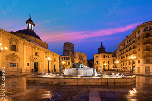 Fountain Rio Turia on Square of the Virgin Saint Mary, Valencia Cathedral, Basilica of Virgen the Helpless at night in Valencia, Spain..