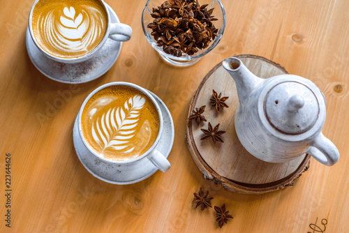 two cups of cappuccino with a beautiful pattern on milk foam. Wooden table with space for text. The view from the top. photo