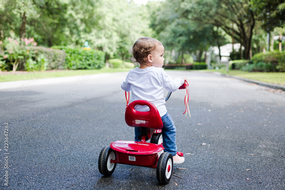 Young Child Toddler Profile on Red Tricycle on a Neighborhood Street Young Child Toddler Profile on Red Tricycle on a Neighborhood Street