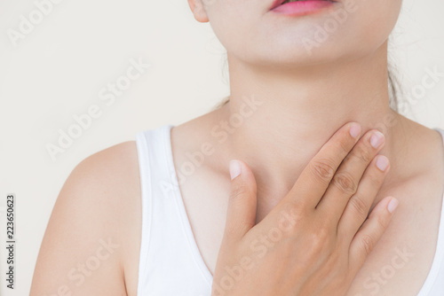 Sore Throat. Closeup Of Beautiful Young Woman Hand Touching Her Ill Neck. Healthcare and medical concept.