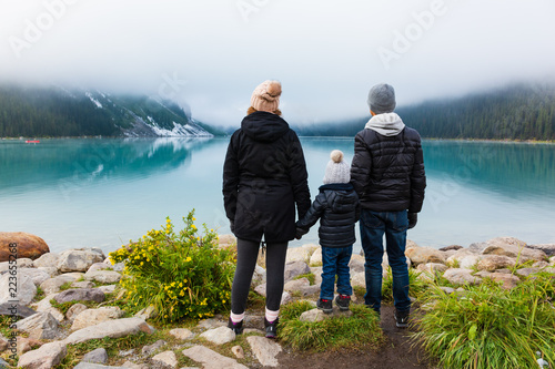 Young family admiring the view at Lake Louise on a foggy day