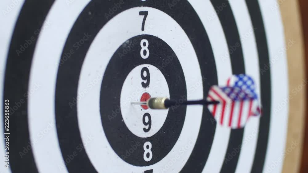 Playing darts on black-white dartboard with darts plumage of USA flag Playing darts on black-white dartboard with darts plumage of USA flag