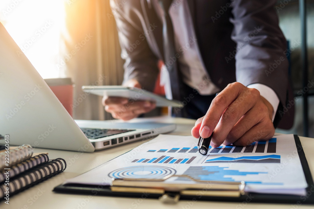 businessman hand using smart phone,tablet payments online shopping,omni channel,digital tablet docking keyboard computer at office in sun light businessman hand using smart phone,tablet payments online shopping,omni channel,digital tablet docking keyboard computer at office in sun light