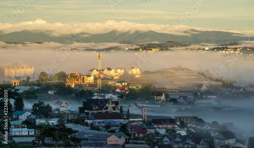 wonderful landscape of Da Lat city, early morning fog covering the city, far away is the green mountains, mist covered the greenhouse under the morning sun