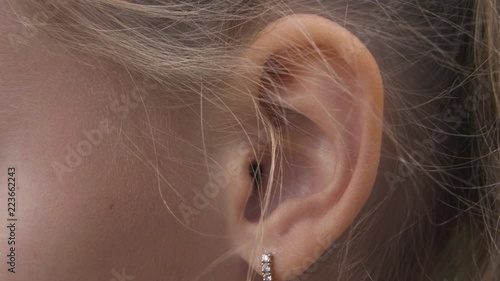 Female ear with earring close up. Ear of woman blonde with decorative piercing photo