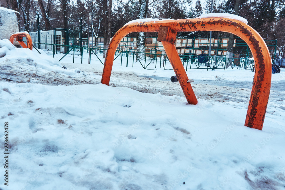 Orange lifting barrier from cars in winter under snow Orange lifting barrier from cars in winter under snow