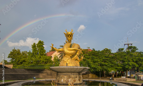Golden Dragon statue in the background sky and rainbow.