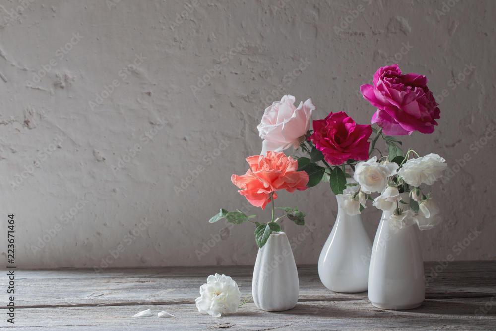 roses in white vases on old background roses in white vases on old background