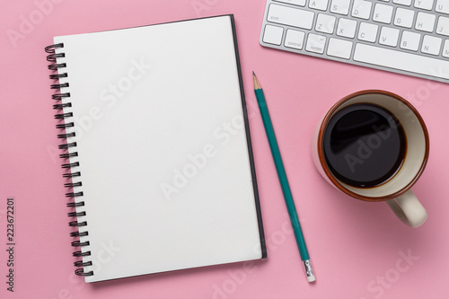 Top view  empty notebook and office supplies on the desk pink background