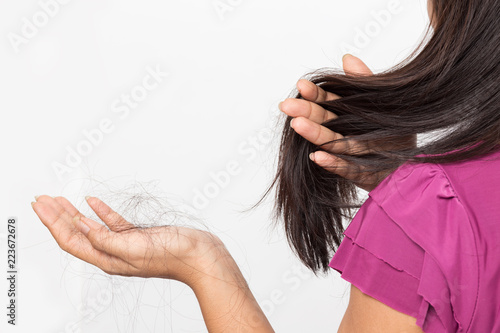 woman worried about Hair loss , young asian female holds loss hair on a white background