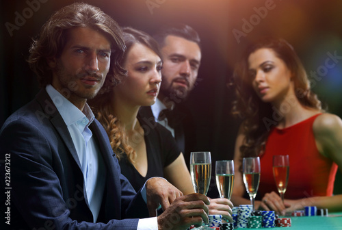 Poker players drink champagne on a black background