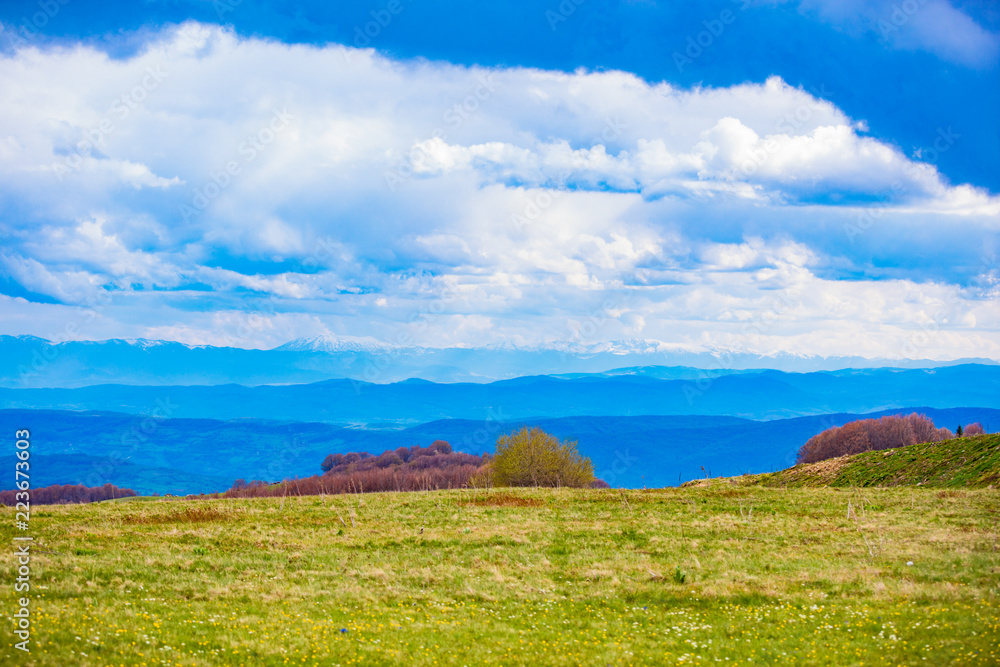 Fototapeta premium Mountain and hill landscape with clouds and fields.
