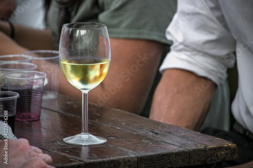 wine glass on wooden table with people, delicious italian beverage 