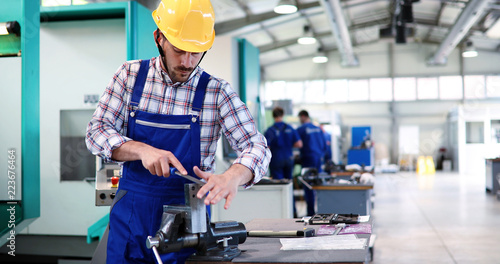 Fotografie Industry Worker entering data in CNC machine at factory