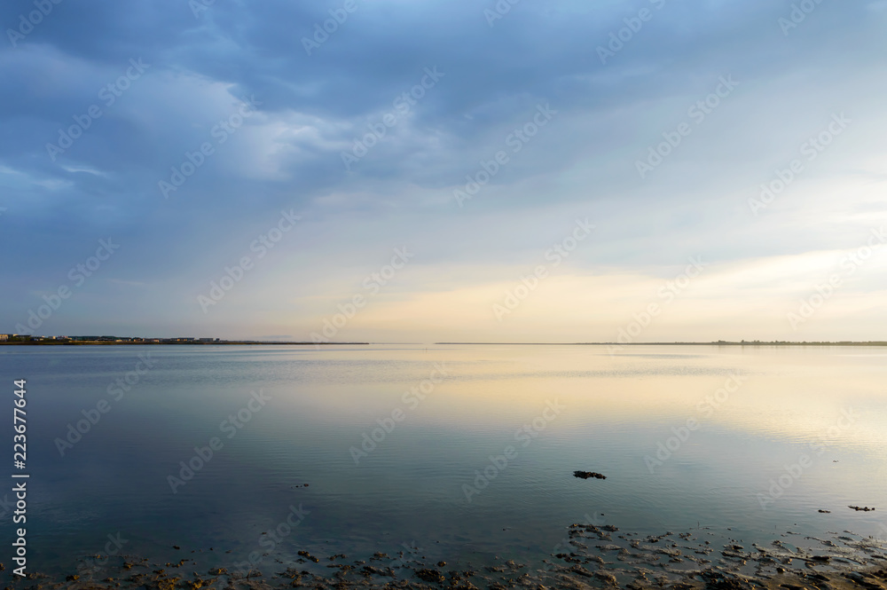 Nice view of the estuary. Sunset over the sea. Calm sea surface. Landscape.