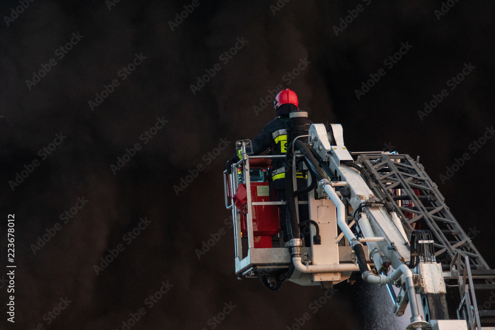 Obraz premium firefighters during the action of extinguishing a powerful fire of a recycling company.Poland, Szczecin