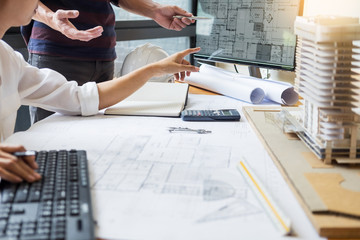 professional architect designer structural engineer team colleagues working office looking computer discussing building plan design project.