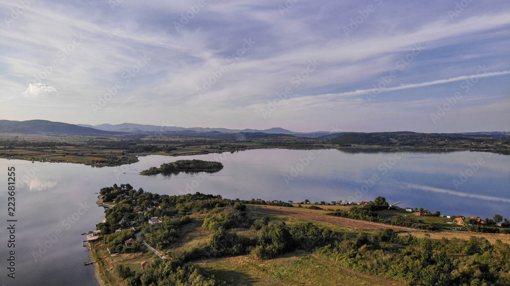 Aerial view of Gruza lake near the village Knic in the Serbia. Reflection of clouds in the lake. Beginning of sunset. Aerial view of Gruza lake near the village Knic in the Serbia. Reflection of clouds in the lake. Beginning of sunset.