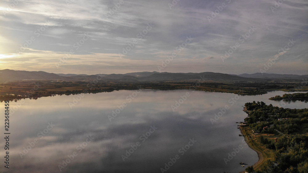 Aerial view of Gruza lake near the village Knic in the Serbia. Reflection of clouds in the lake. Beginning of sunset.