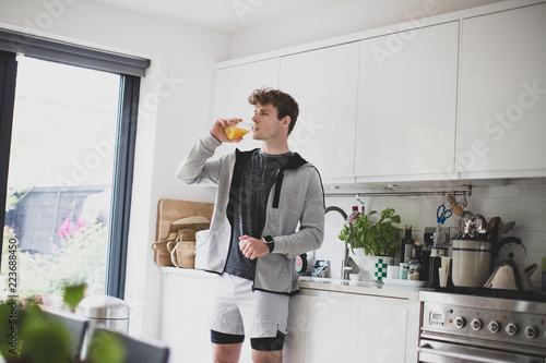 Young adult male drinking orange juice before after a run photo