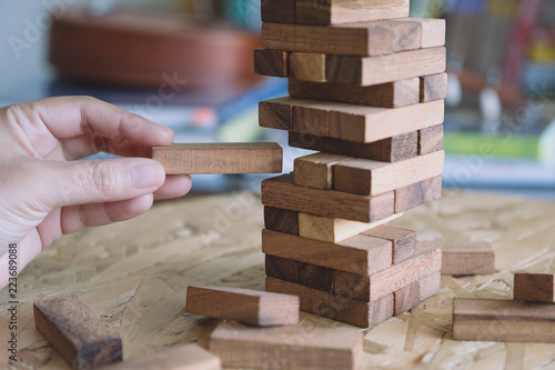 Closeup image of a hand holding and playing Tumble tower wooden block game