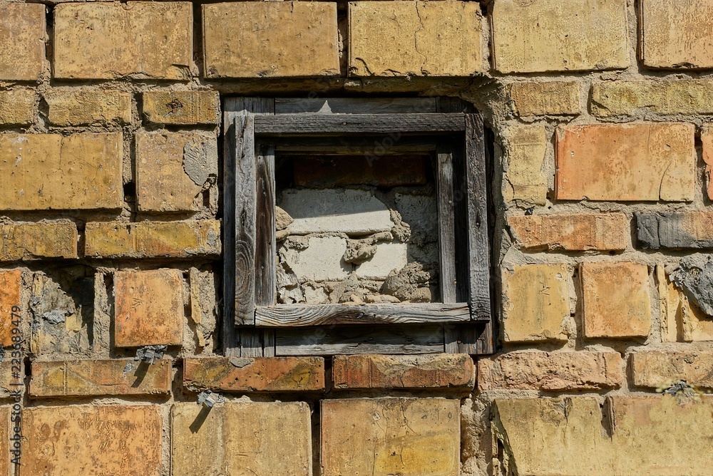old small walled window on the brick wall of the building old small walled window on the brick wall of the building