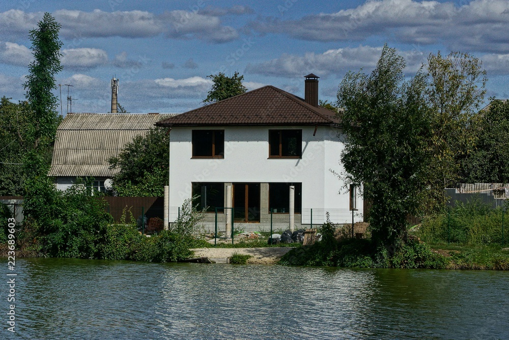 large private white house with windows near the water on the shore of the reservoir large private white house with windows near the water on the shore of the reservoir