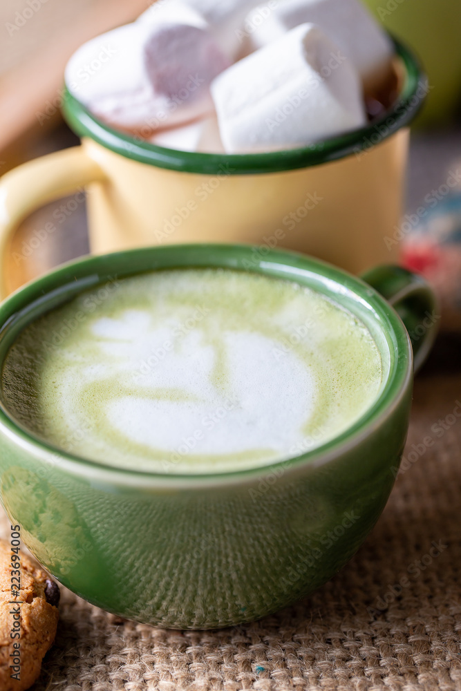 A cup of hot matcha latte on wooden floor A cup of hot matcha latte on wooden floor