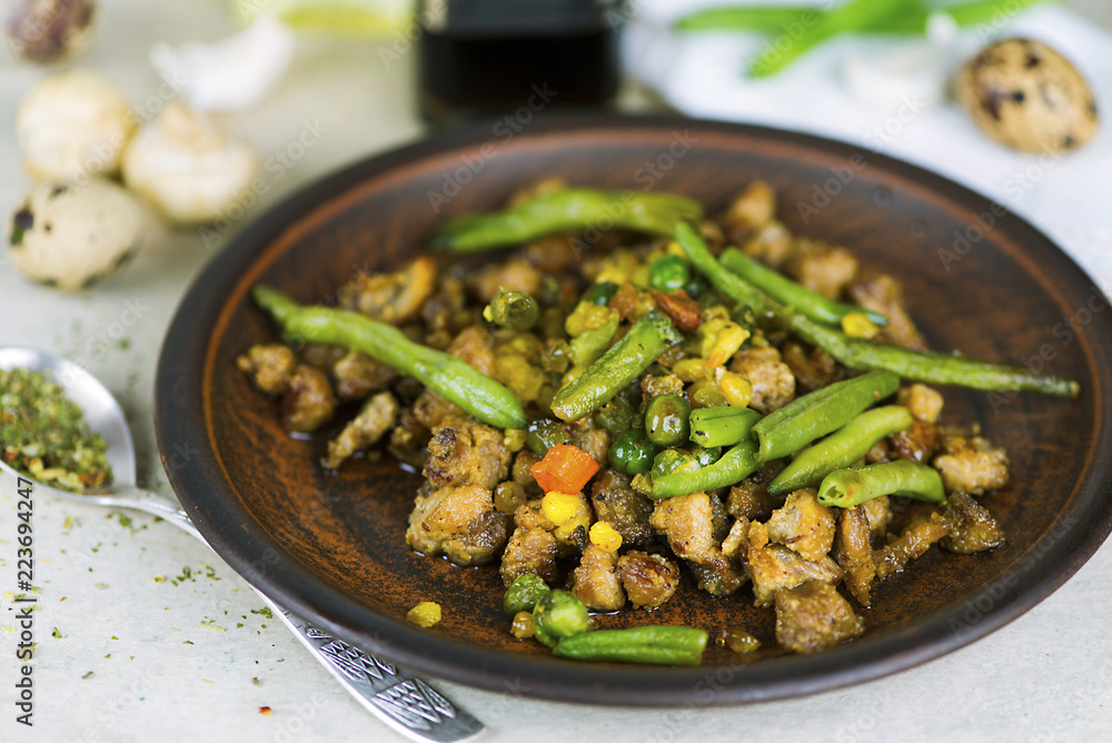 fried meat with vegetables and asparagus with spices on a plate
