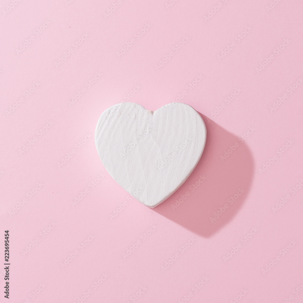 White heart with pink background. Minimal love or like concept. Flat lay.