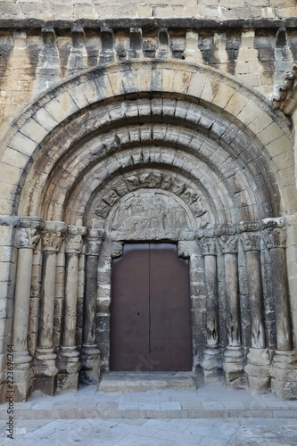 The Romanesque entrance of the Nicholas of Bari Church (Iglesia de san Nicolas de Bari), with the typical low reliefs in the small rural Aragonese town of Frago, Spain